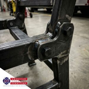 Close-up of reinforced steel mechanism on a heavy-duty firehouse recliner.